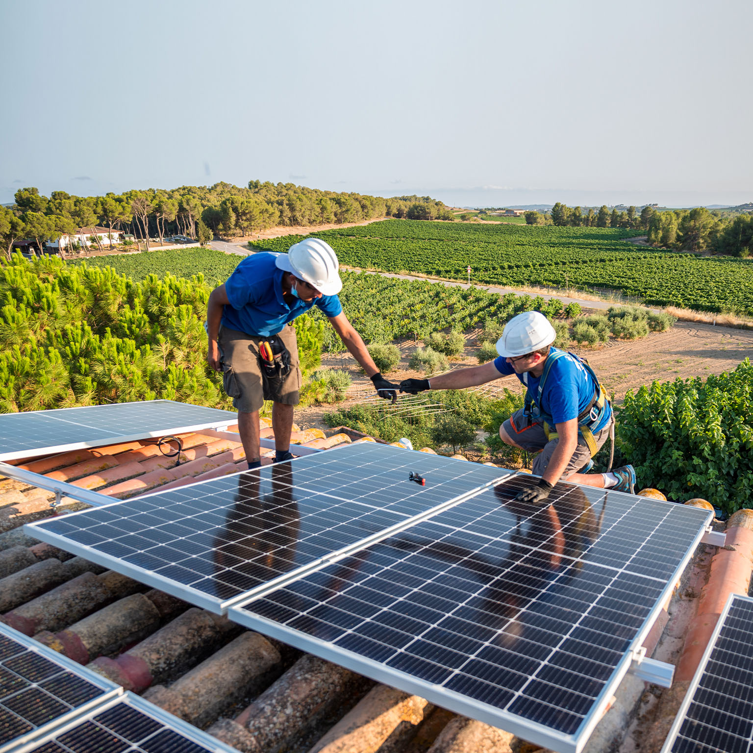 Two workers installing solar panels - stock photo