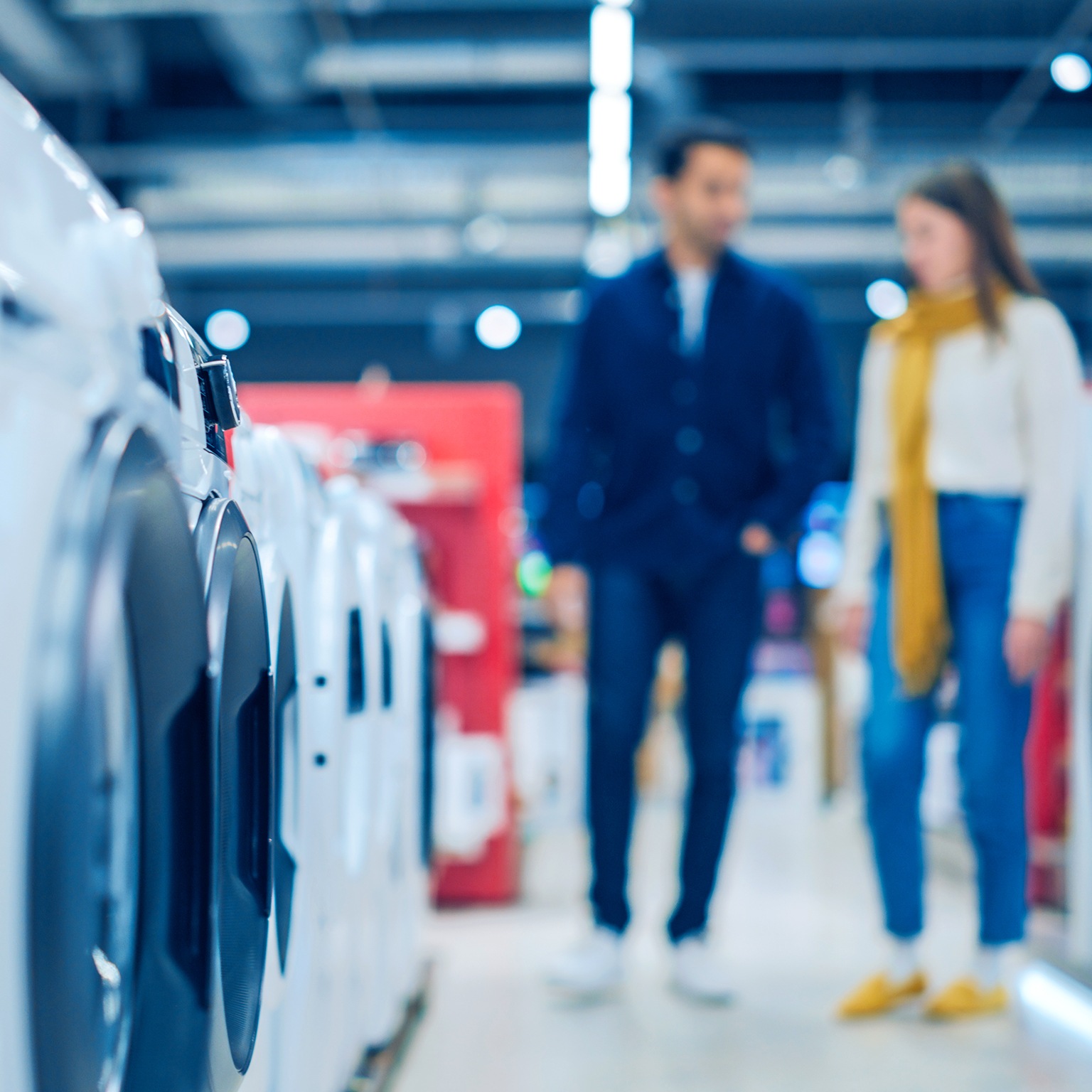 Customers explore modern laundry solutions in a retail shop.