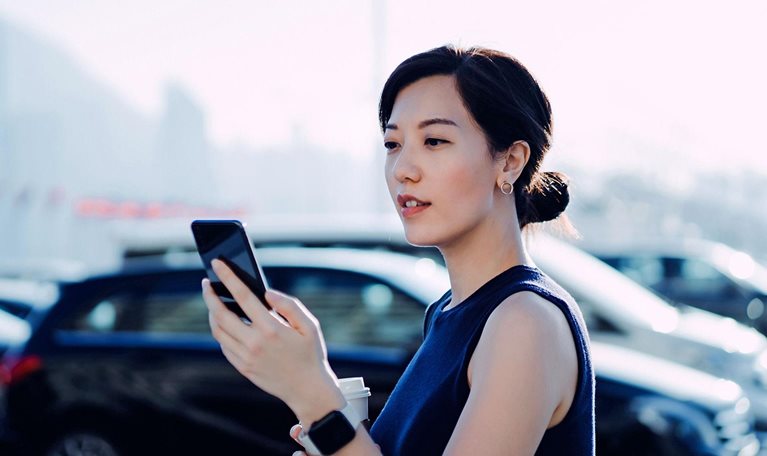 Woman in parking lot checking her phone