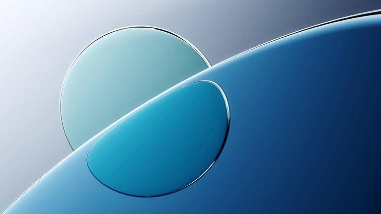 An abstract image of a curved, shiny surface of water with a lighter circle behind and refracted through it.