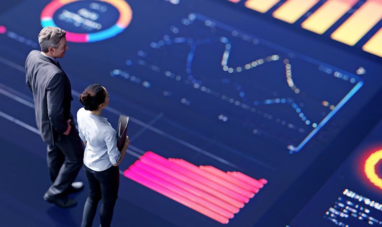 3d conceptual rendering of two business people standing on a large digital screen, analyzing data visualizations.