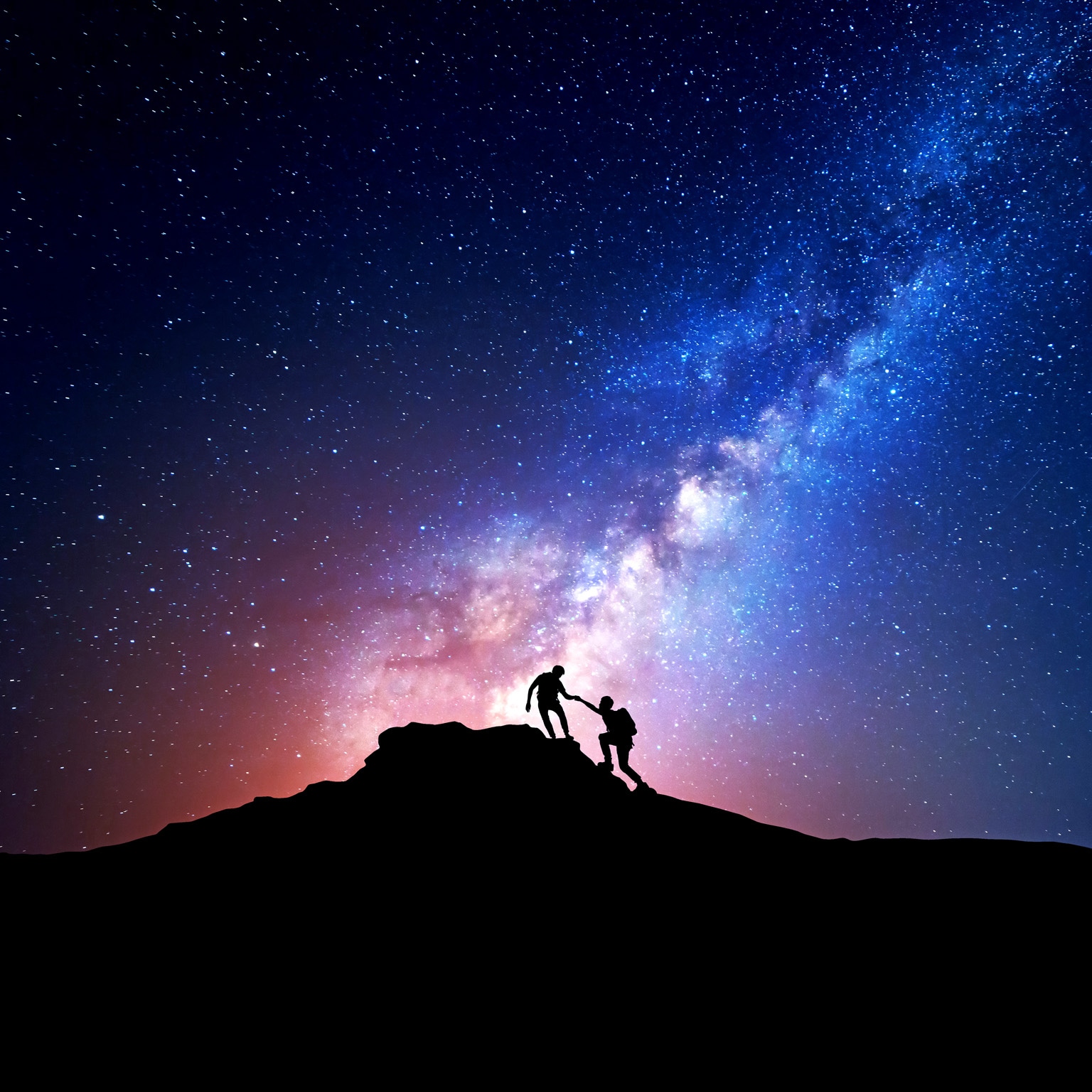 Silhouette of people climbing mountain at night