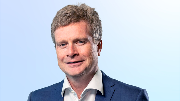Sean Doyle in a suit against a light blue background