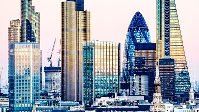 Sunset view of London's financial district, including The Gherkin and The Shard.