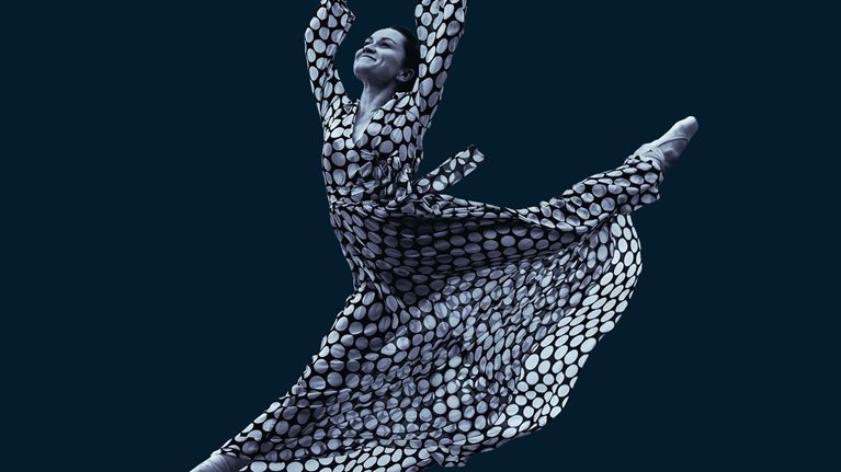 Dancing woman in dress in mid-air jump