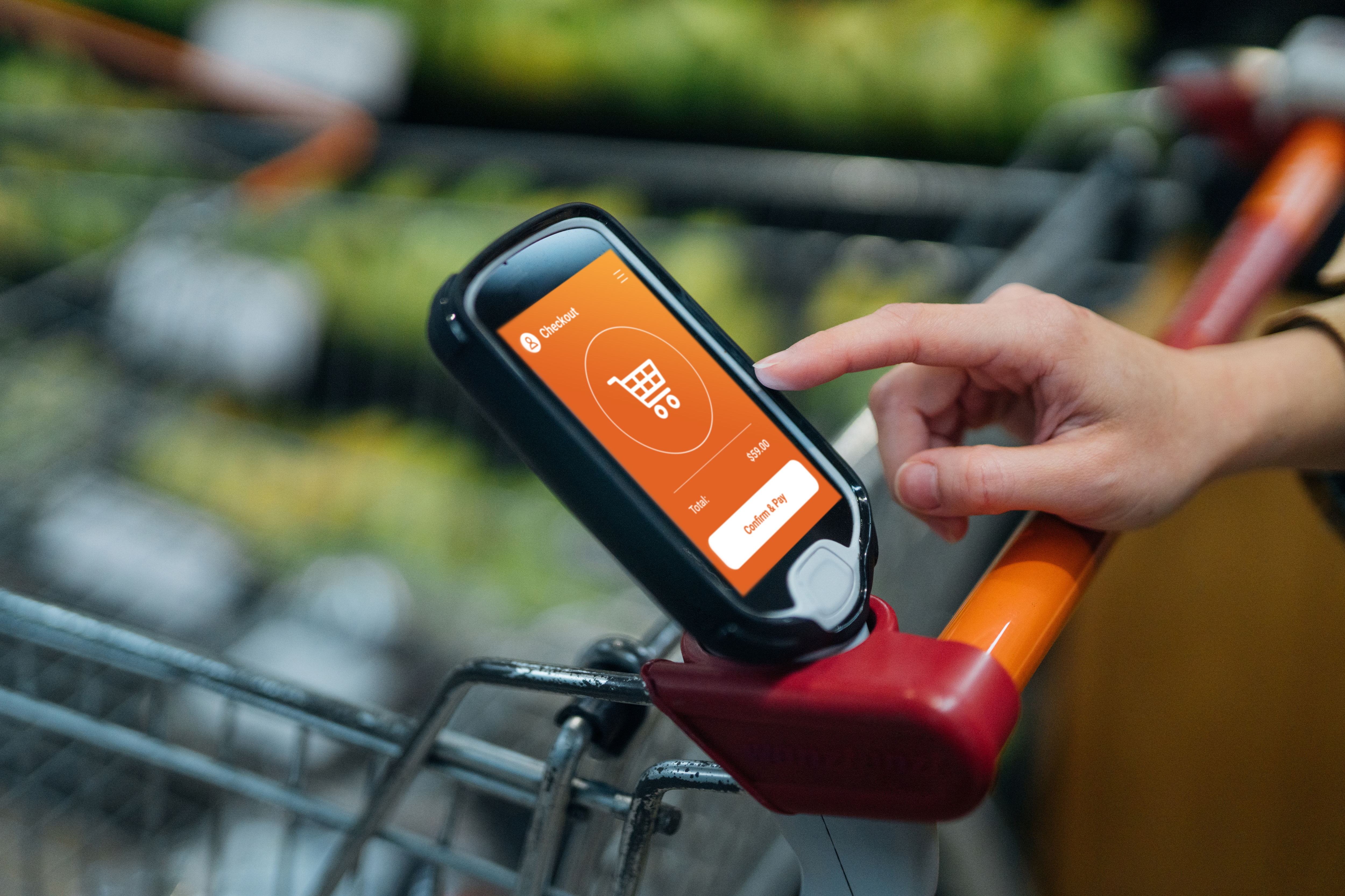 Close up shot of female hand touching a digital device on the shopping cart in supermarket. Smart shopping makes grocery shopping convenient. Contactless payment concept.