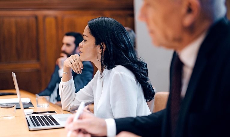Three executives in a board room meeting
