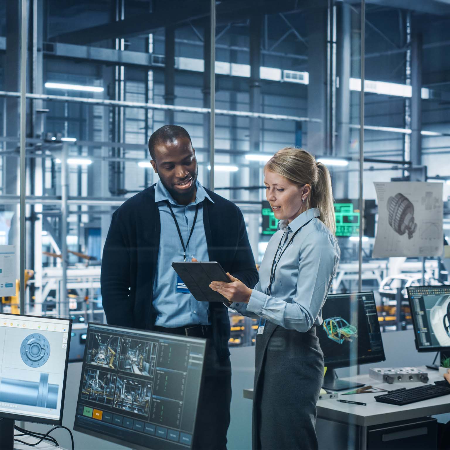 Car Factory Office: Female Engineer Talks with Male Scientist, Use Tablet Computer to Design Production Conveyor for Advanced Power Engines. Automated Robot Arm Assembly Line Manufacturing Vehicles