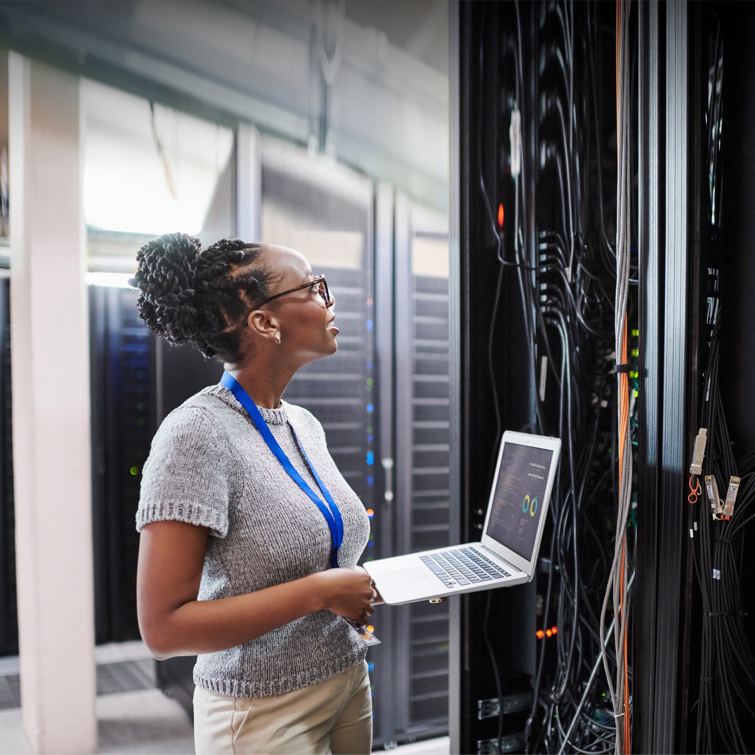 Shot of a young woman using a laptop in a server room - stock photo