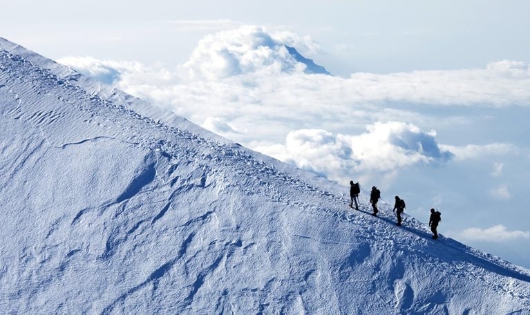 Climbers ascending on a snow mountain peak