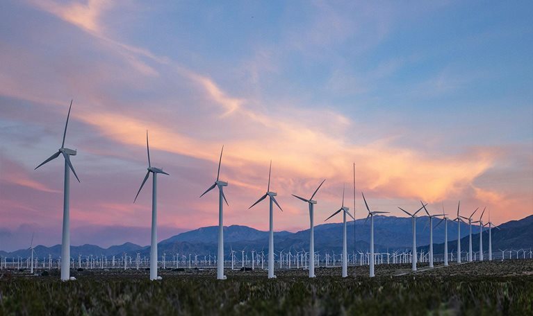 sunset falls as wind turbines spin