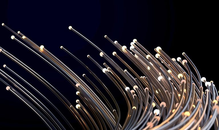 Thin metallic wires of different lengths with small lights at their ends bending together against a dark background for added drama.