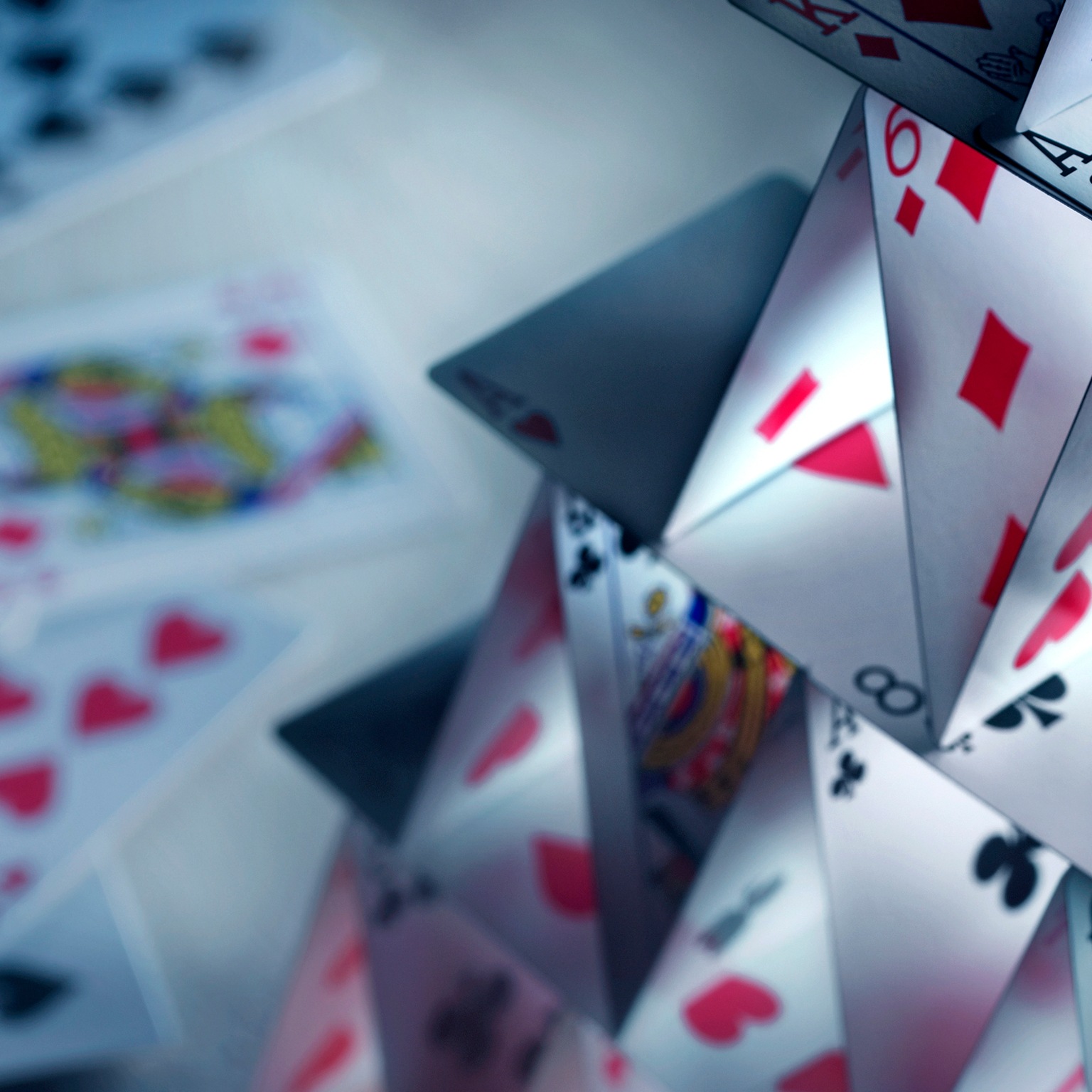 A house of cards built with a variety of playing cards.