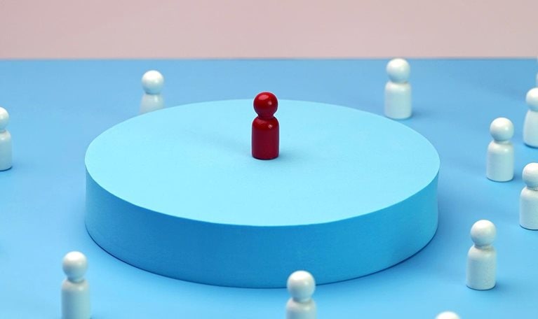 Visionary leader symbol with unique and creative solution. Single wooden block doll standing on elevated platform, other wooden block dolls gathered around listening.