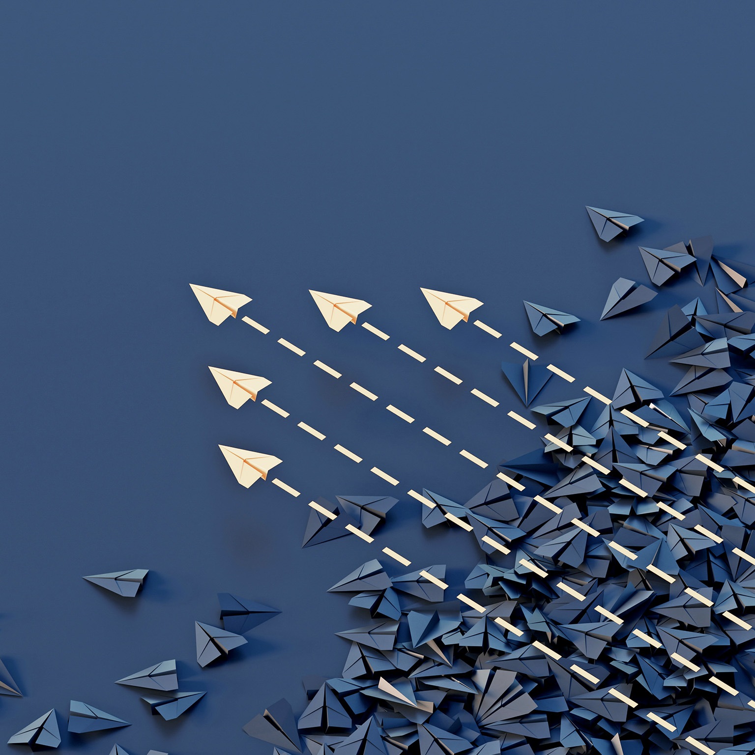 Conceptual image showing a jumble of dark paper planes with an organized group of colored planes flying through and above them.
