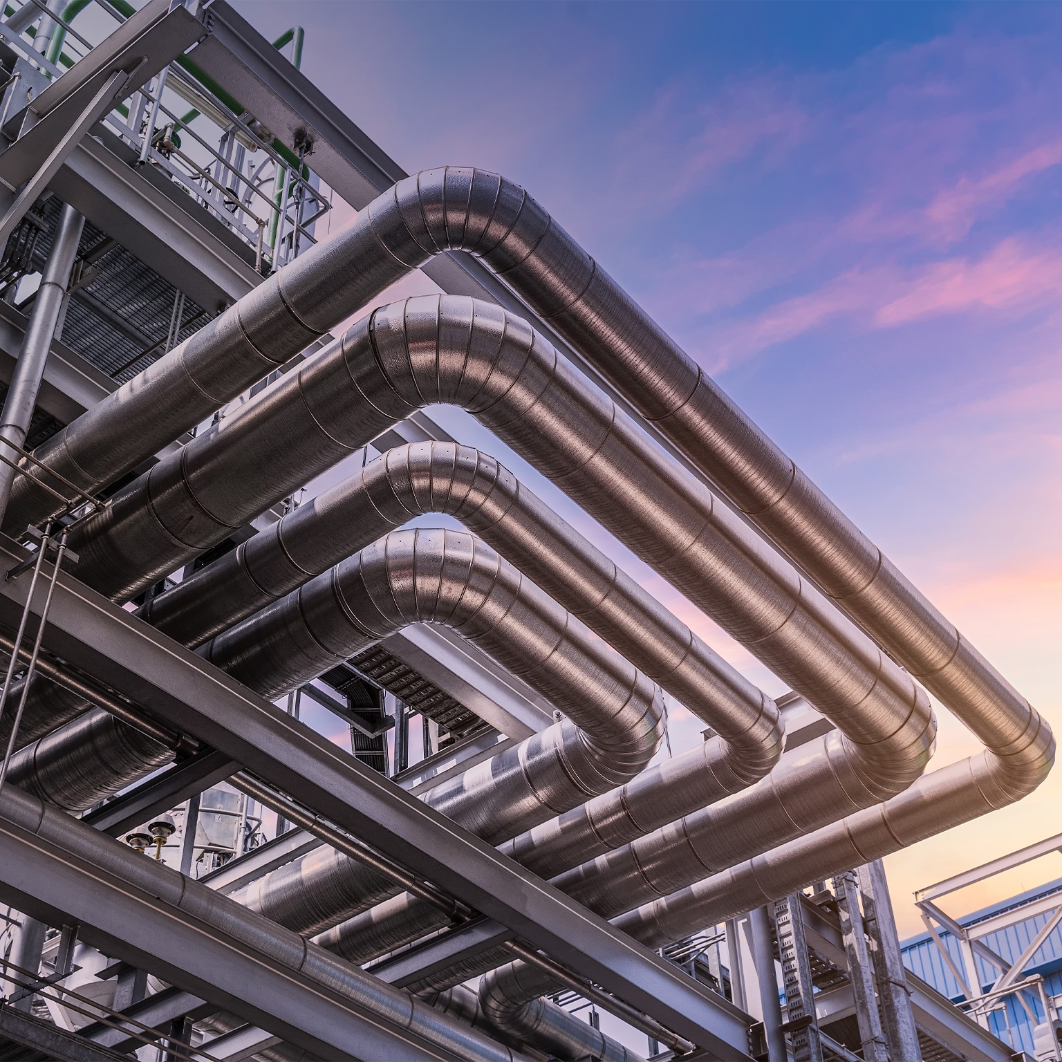 Steel pipelines and valves at at oil-refinery plant and sky - stock photo