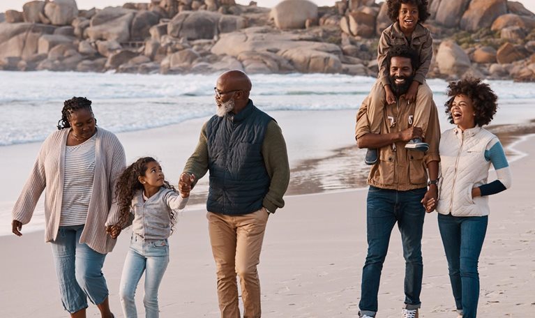 photo three generational family walking on beach