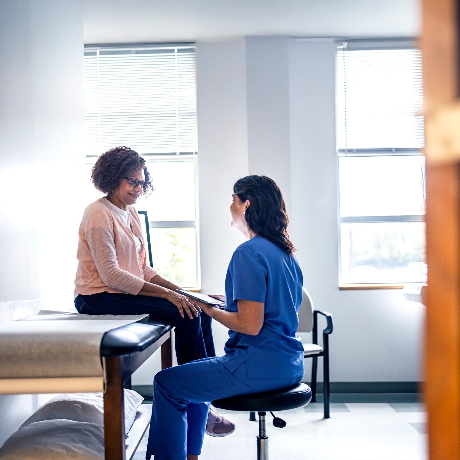 Doctor and senior woman discussing treatment in doctors office