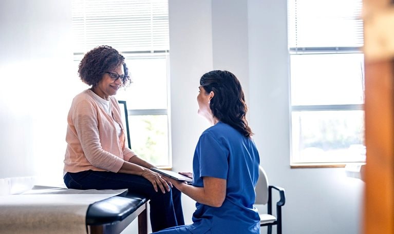 Doctor and senior woman discussing treatment in doctors office