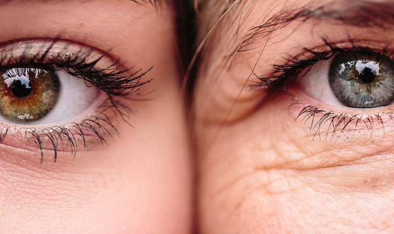 Close up on eyes of mother and daughter faces next to one another.