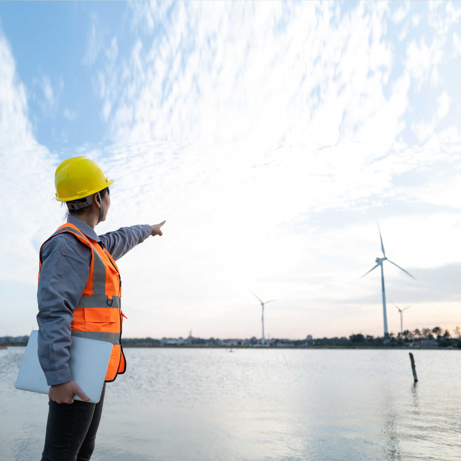 Female engineer manager finger in front of wind power station - stock photo
