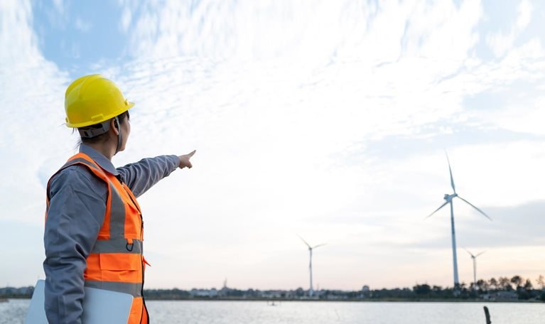Female engineer manager finger in front of wind power station - stock photo