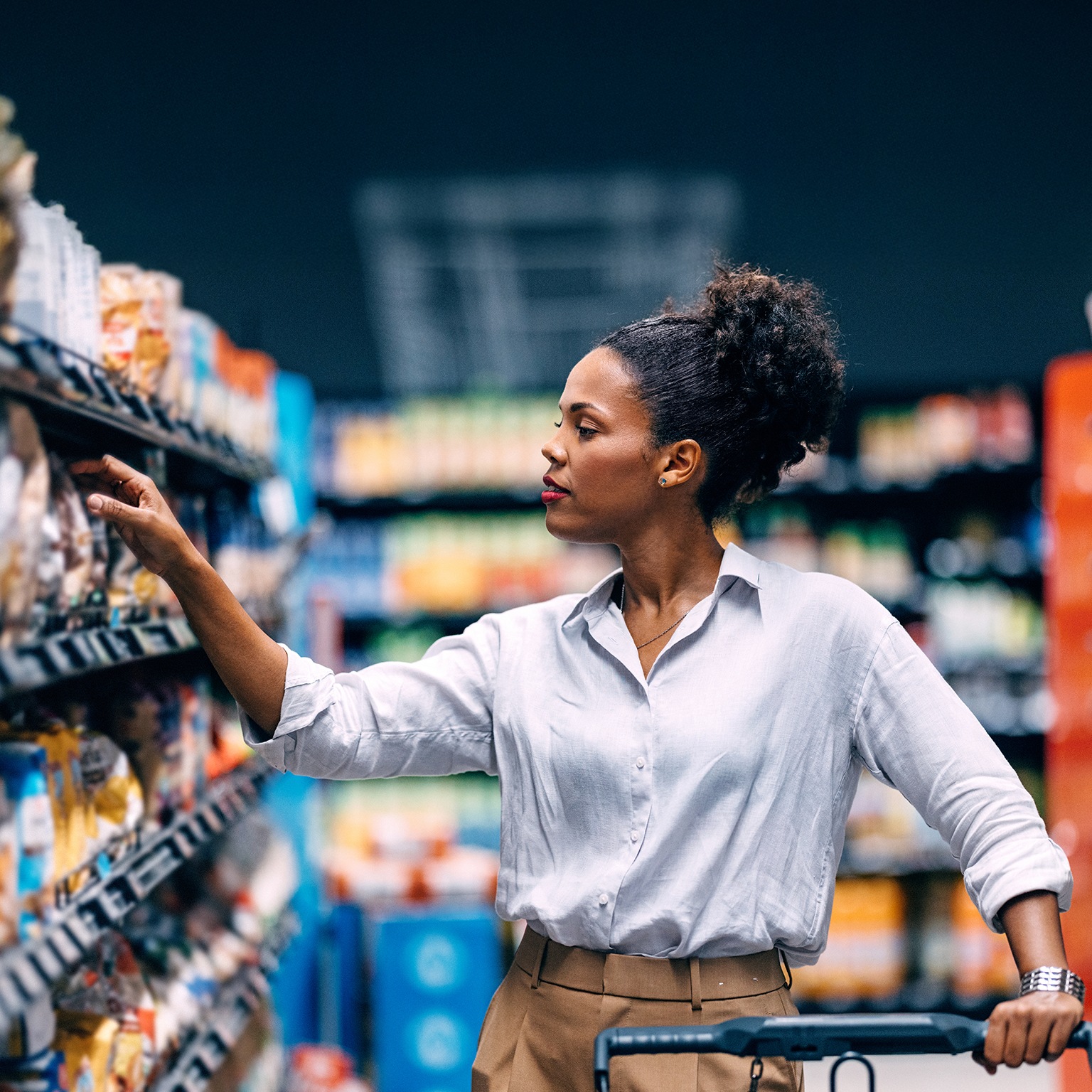 Woman Shopping in Supermarket Aisle Searching for Products