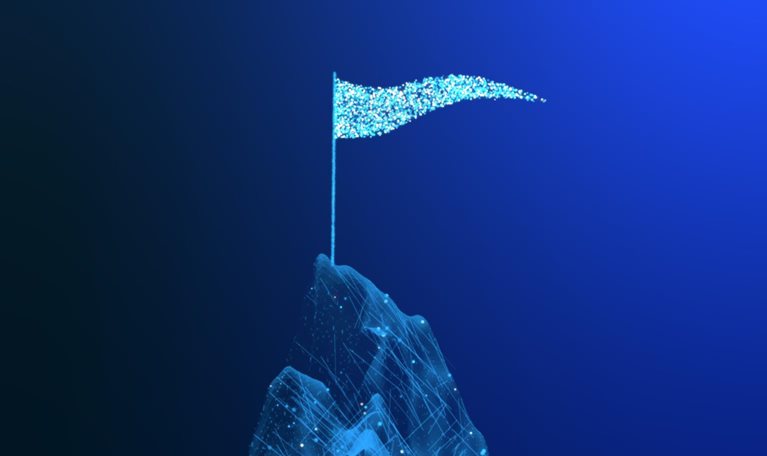 Animated blue particles form a mountain peak against a dark background. A flagpole rises from the summit, and a glowing blue flag waves as small particles drift away.