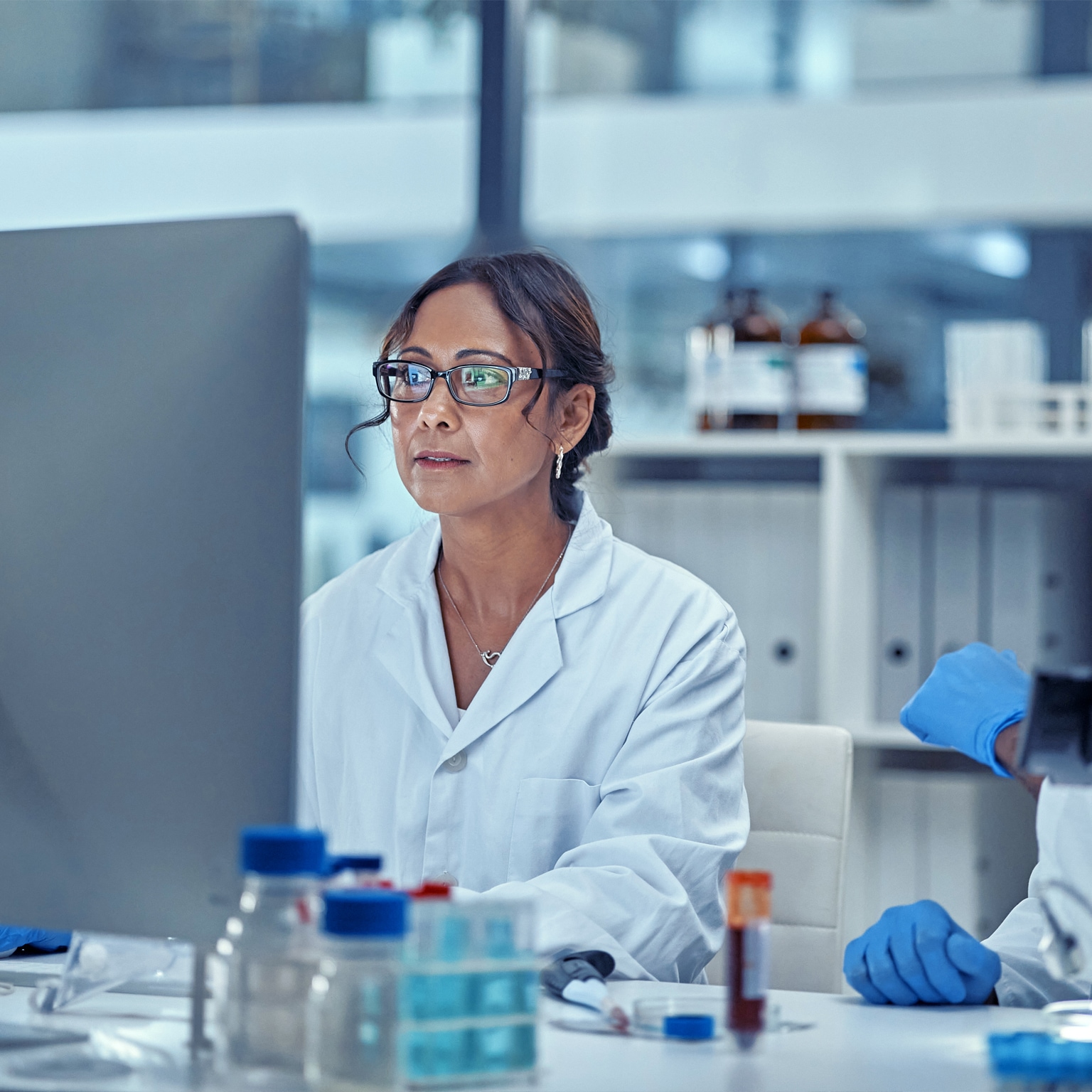 Two scientists working together on a computer in a lab focused on finding the right results