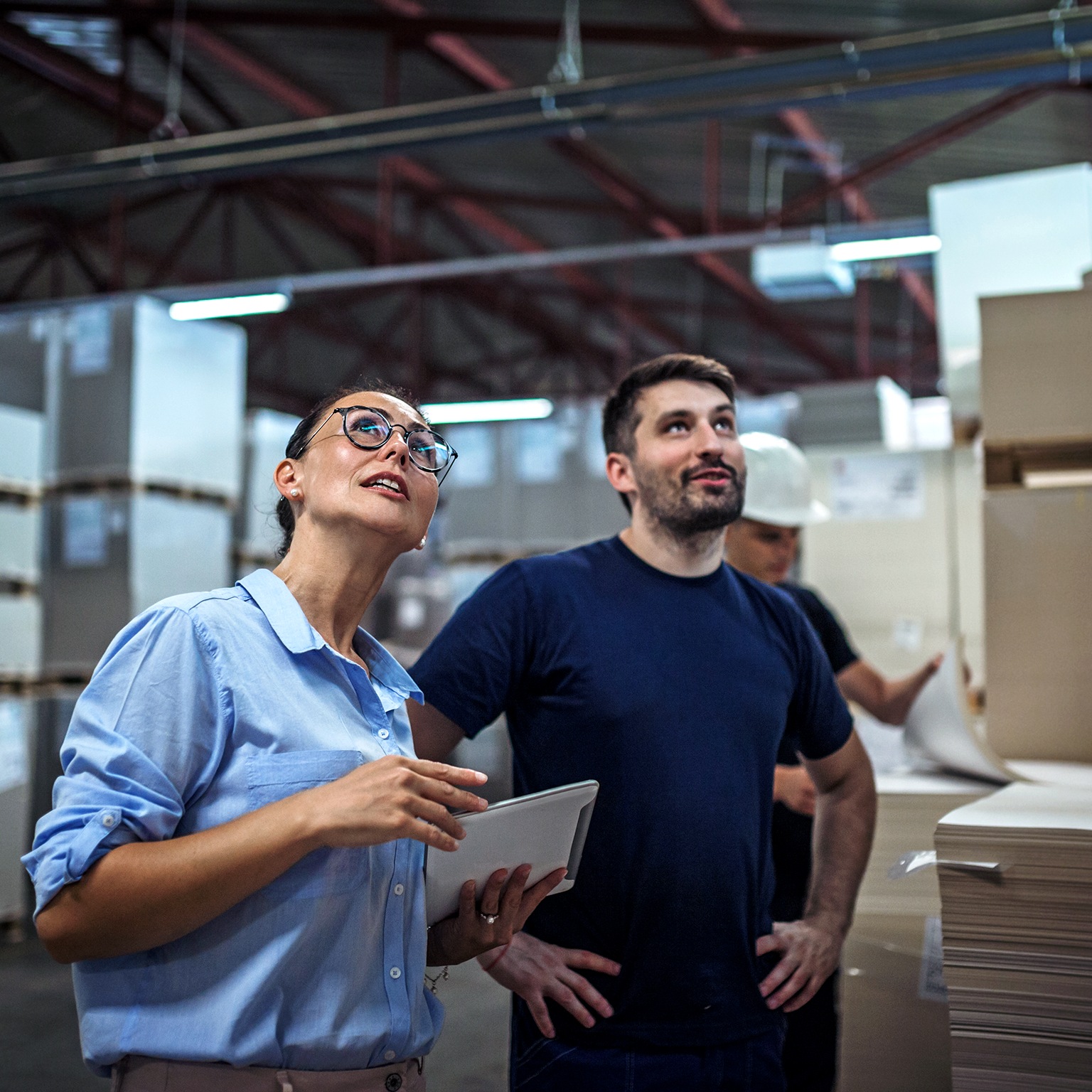 Image of a warehouse supervisor walking and talking with a senior manager while inspecting a warehouse.