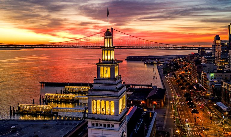 Aerial view of the Embarcadero with a burning sunrise and the Ferry Building