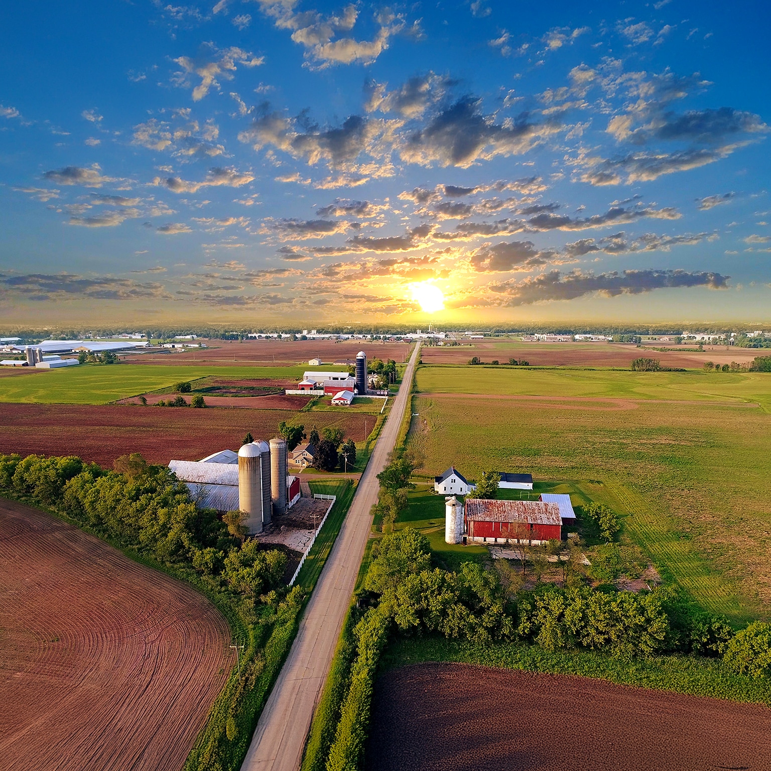 Idyllic rural agricultural landscape with dramatic sky at dawn