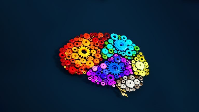 Colorful gears forming the shape of a brain on a dark blue background.