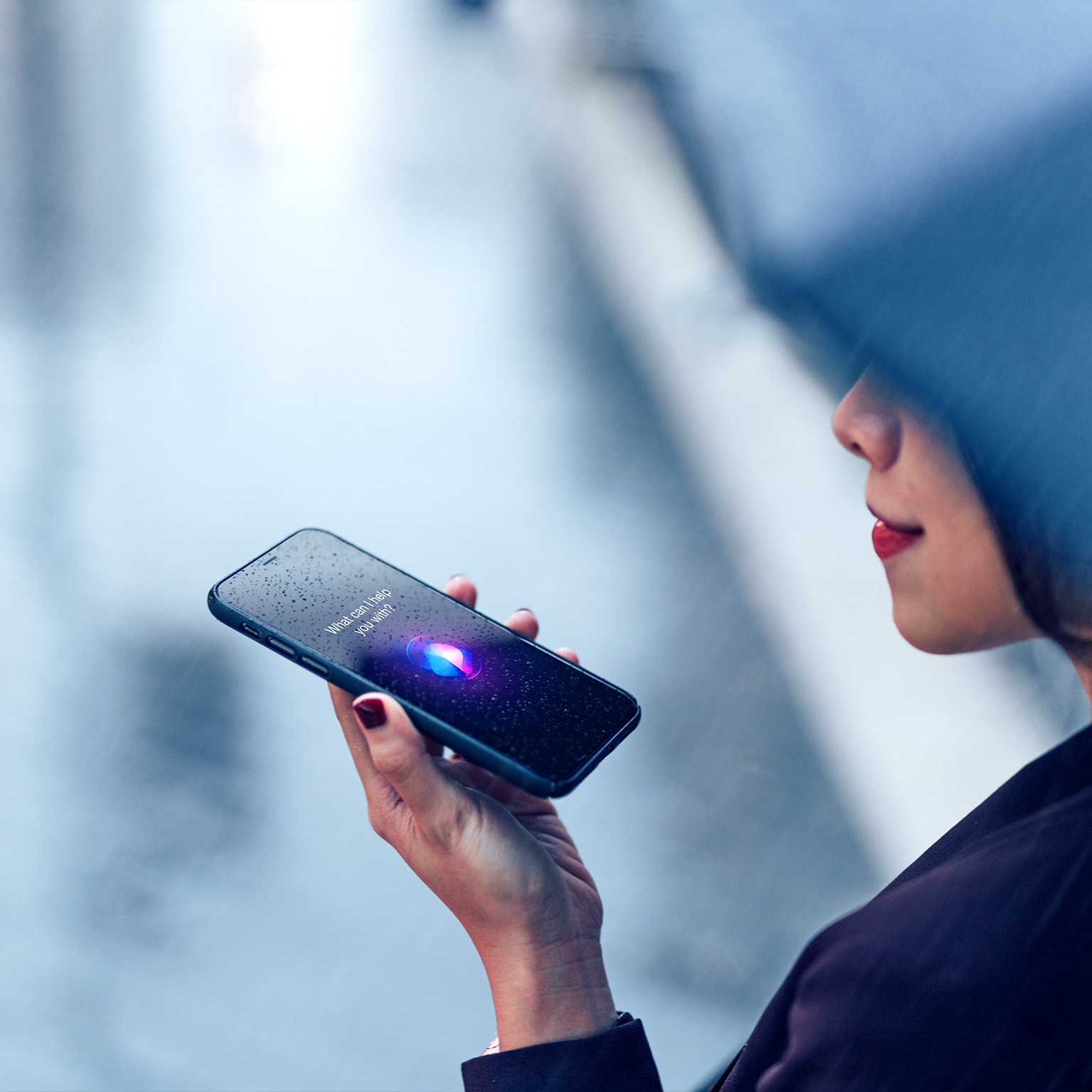 Image of a woman using voice assistant on smartphone in the rain.