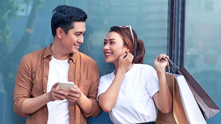 A picture of a couple shopping with smartphone in the city