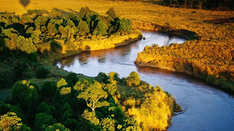 The view from the air, on a balloon safari over Masai Mara National Reserve in Kenya. The shadow of the balloon can be seen in the distance. - stock photo