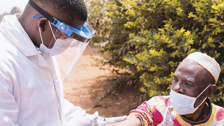 Senior African man getting vaccinated outdoor during Covid-19 pandemic era photo
