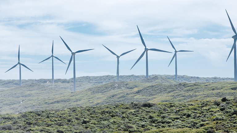 Image of several wind turbines in motion