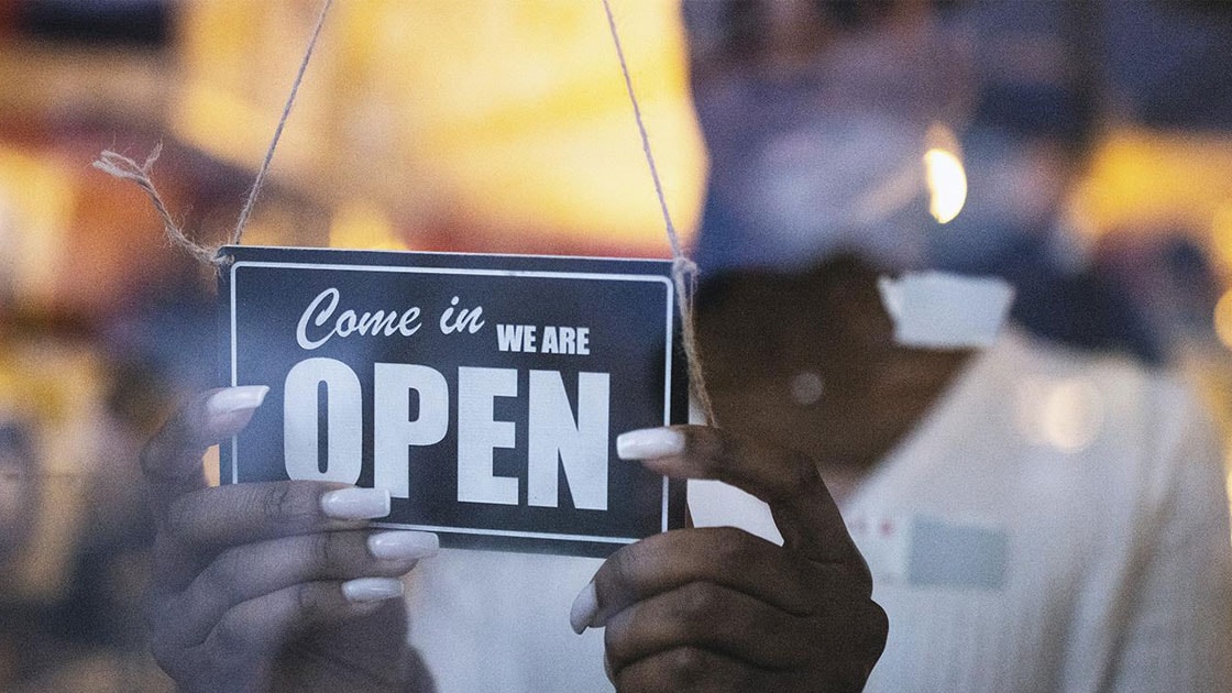 person putting an open store sign