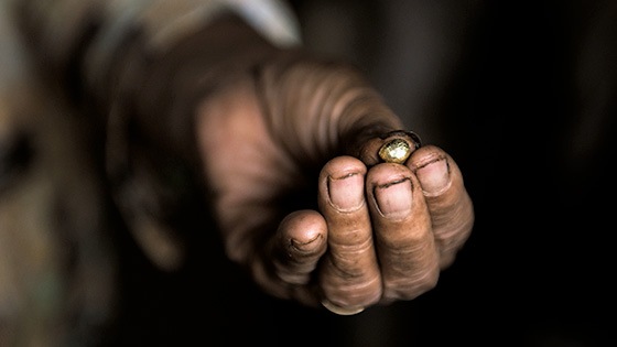 A close up of a hand holding a piece of gold