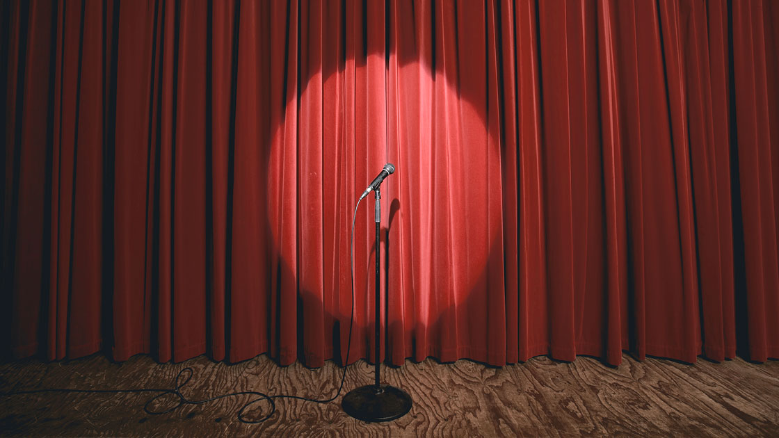 photo of a red stage curtain and microphone