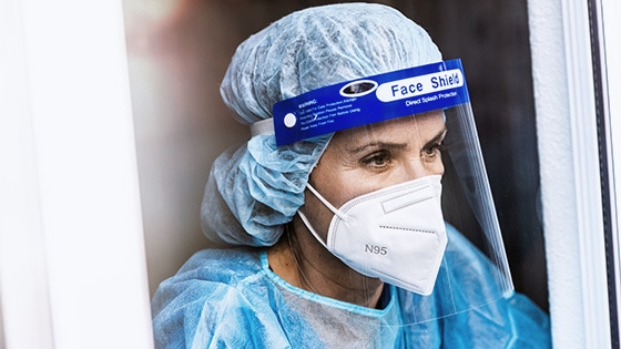 A photo of a nurse wearing personal protective equipment and scrubs