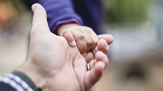 A photo of a child's hand holding an adult hand