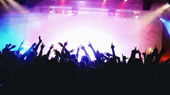A photo of a crowd in front of a rock concert stage