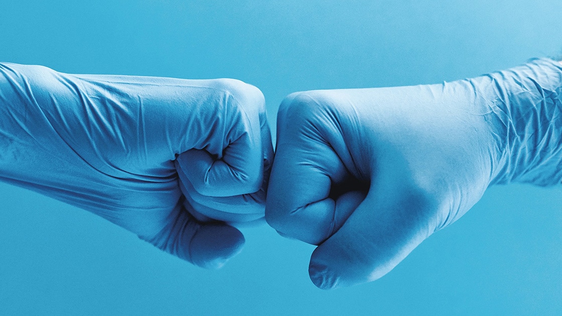 Image of two gloved hands fist bumping