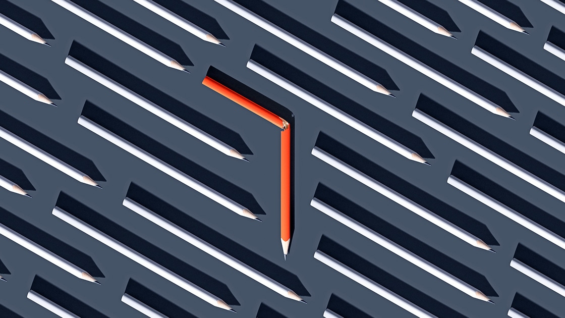 Outline of an orange pencil shape amid many black-and-white pencil shapes