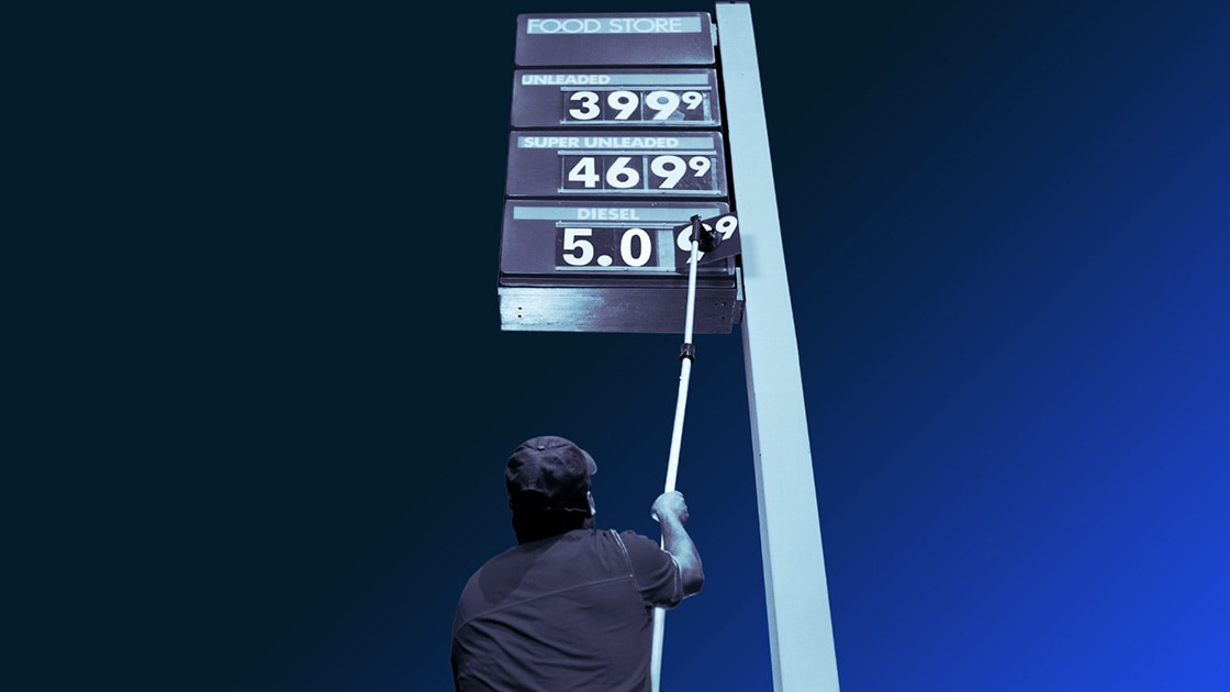 Image of a worker manually updating a gas prices board
