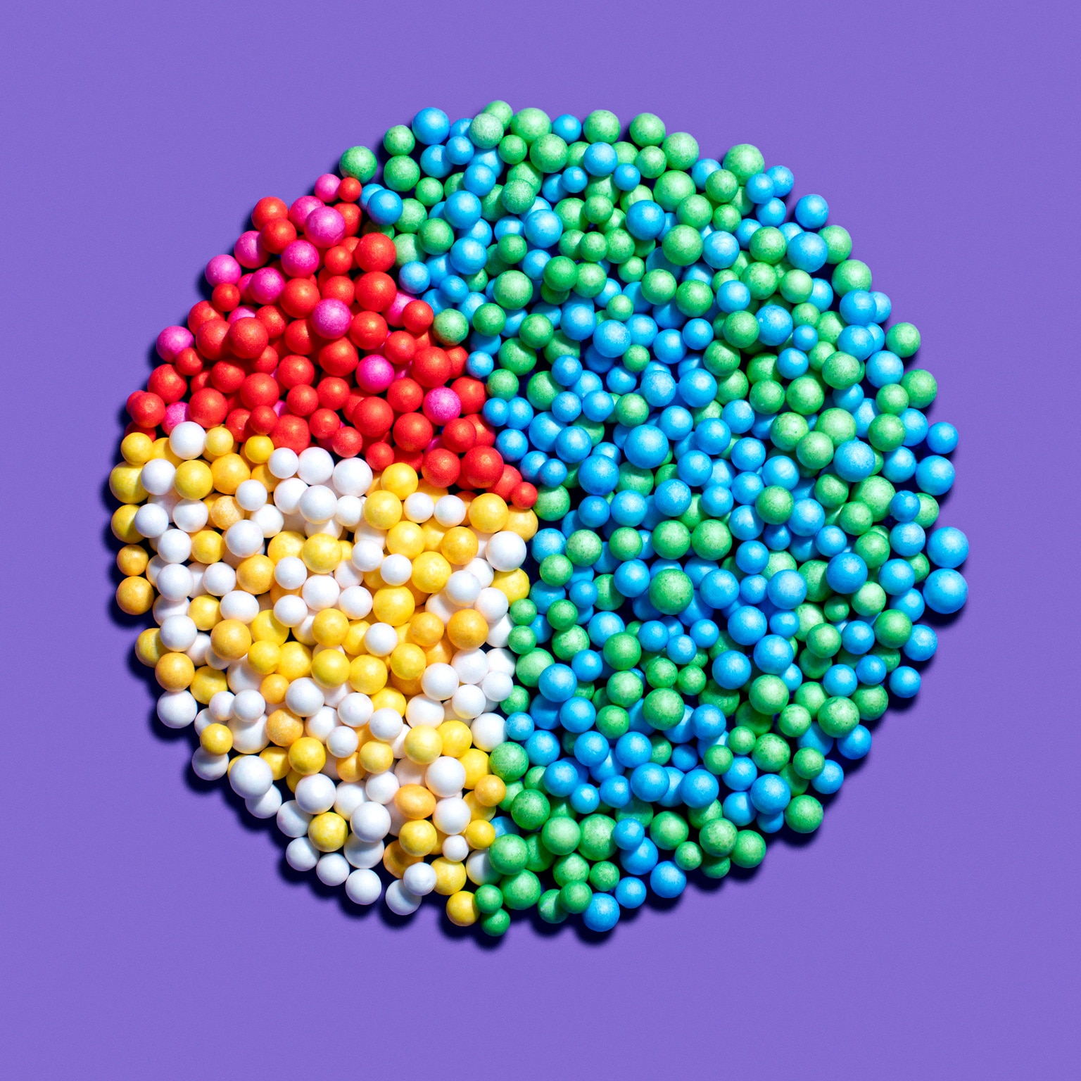 Image of a pie chart represented in various colored pellets on a purple background