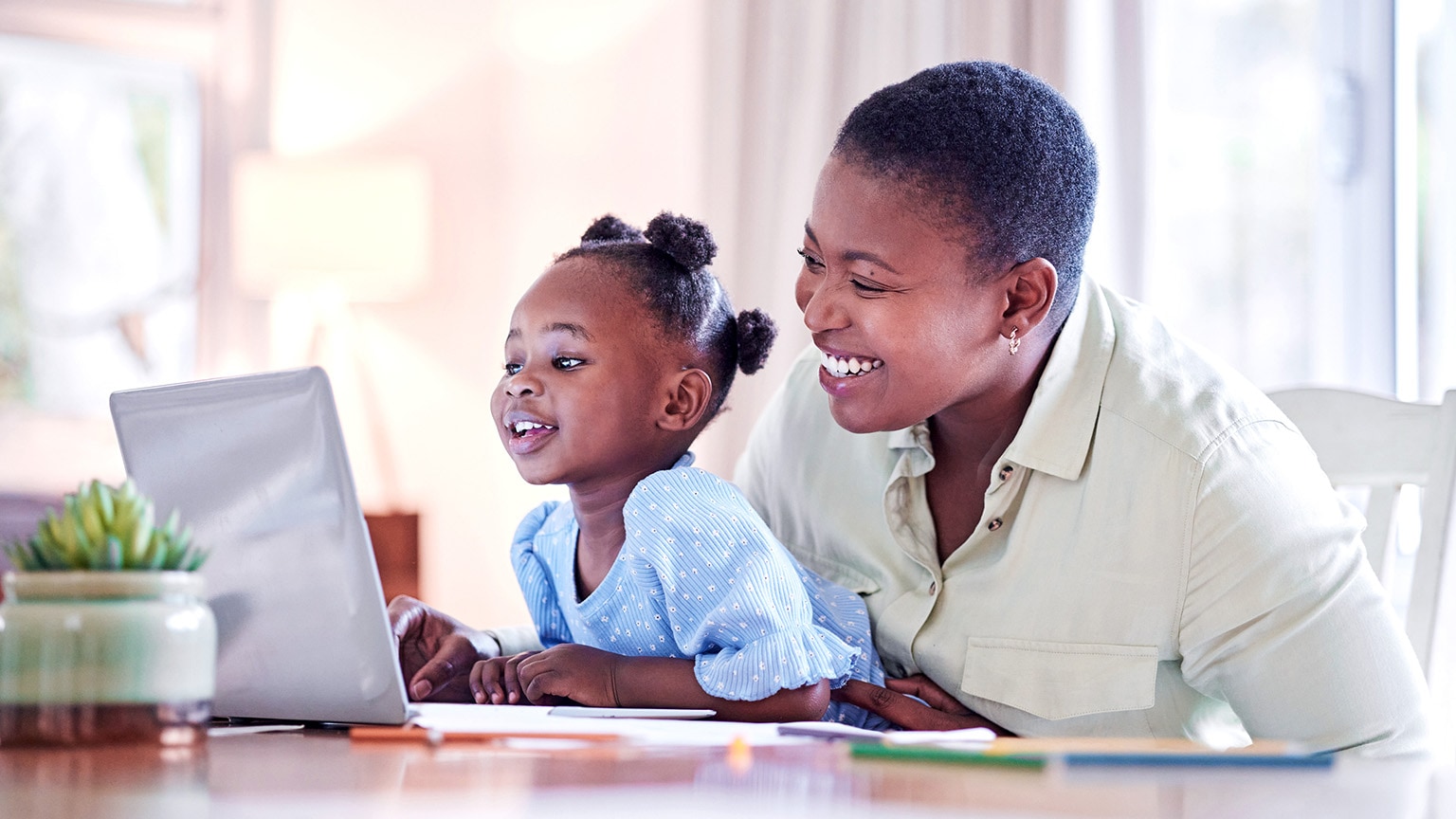 Image of a Black woman and her daughter using a laptop