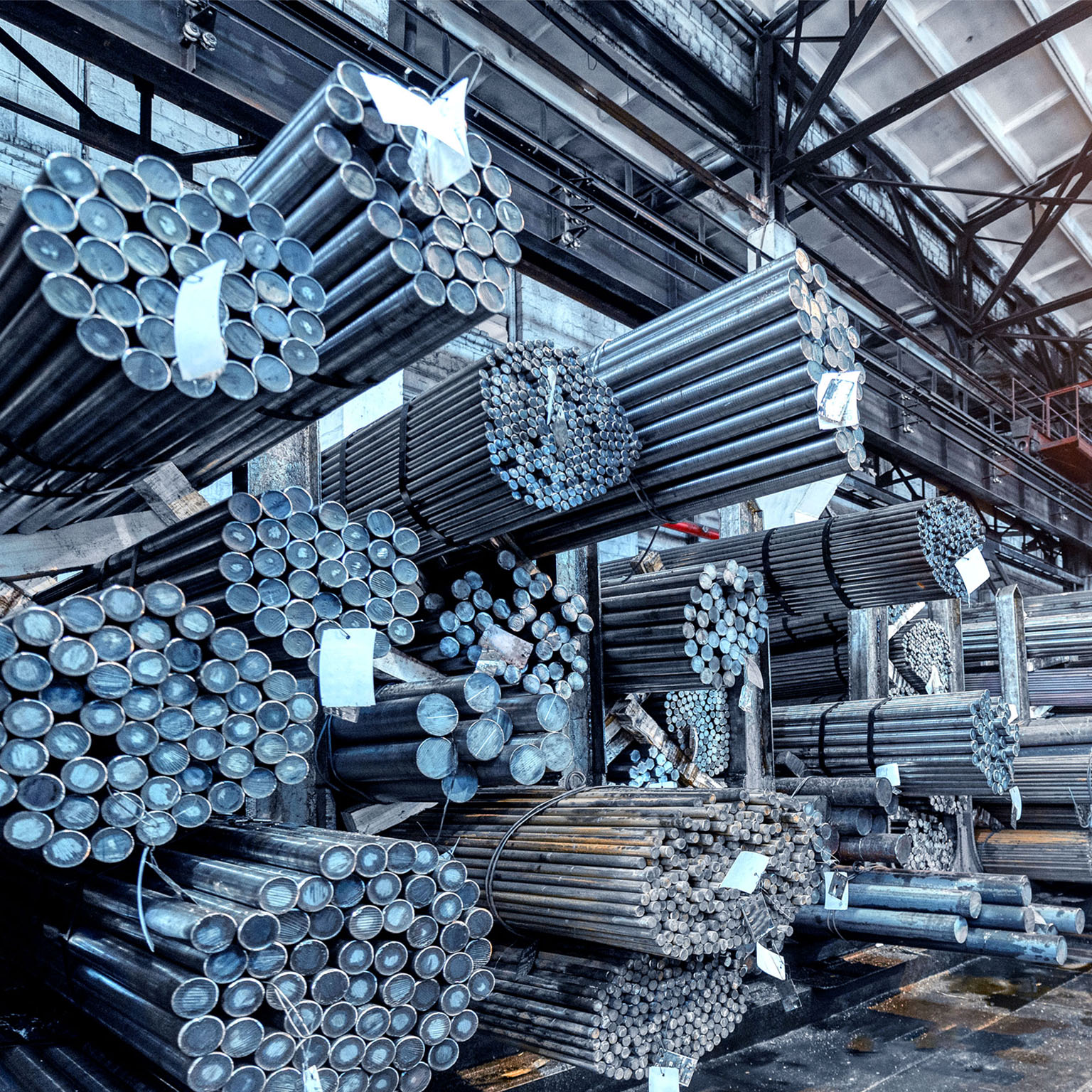 Image of several large bundles of aluminum tubes in a warehouse